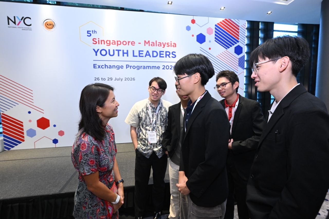 Delegates speaking with an organiser at the programme opening
